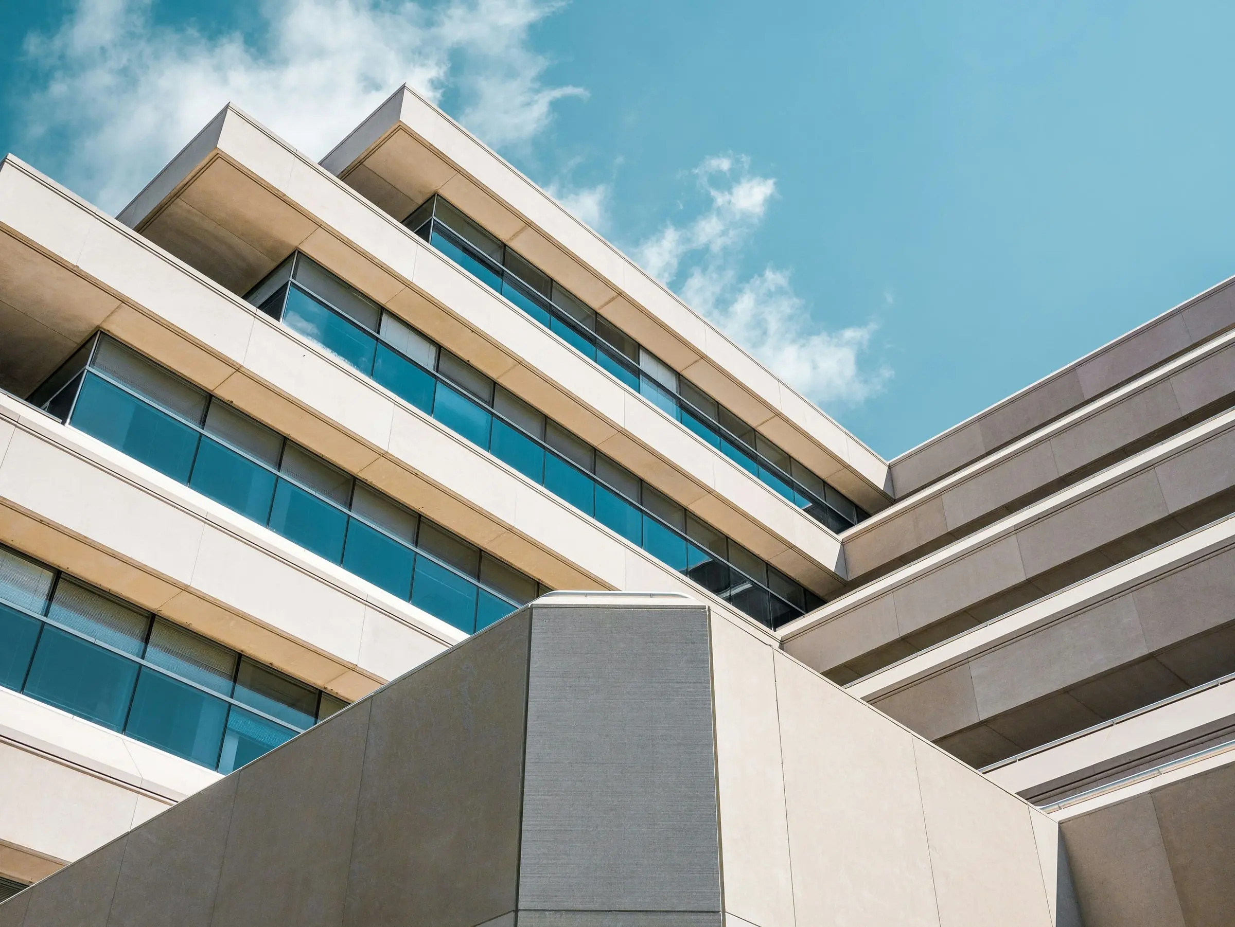 Modern office building with teal glass seen from below